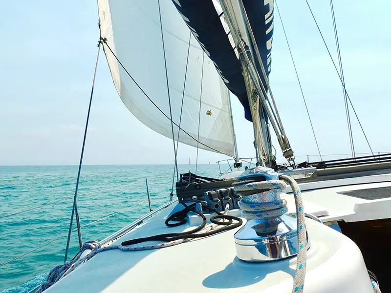 Velero navegando en mar abierto con las velas desplegadas, simbolizando el rumbo firme y controlado hacia el éxito empresarial con Duc Capital.